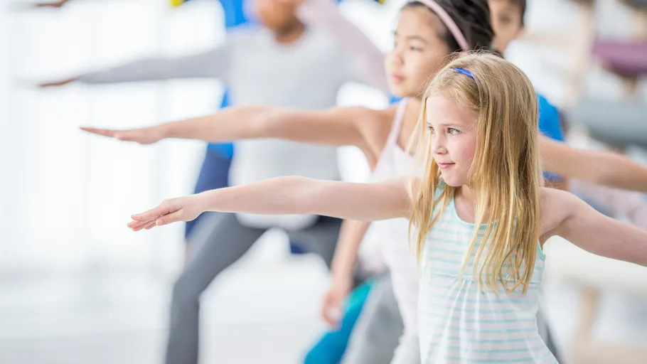 Children practicing yoga in a bright room.