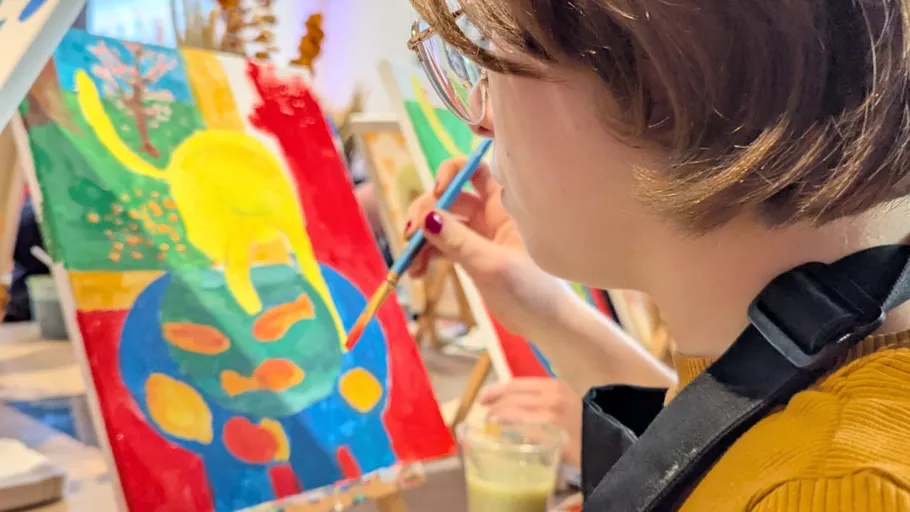 Person painting colorful abstract art on canvas.