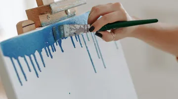 Hand painting blue on white canvas.