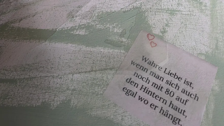 Note with text and two hearts on textured surface.