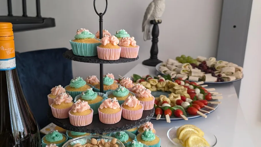Cupcakes on stand, snacks on table, decorative bird.