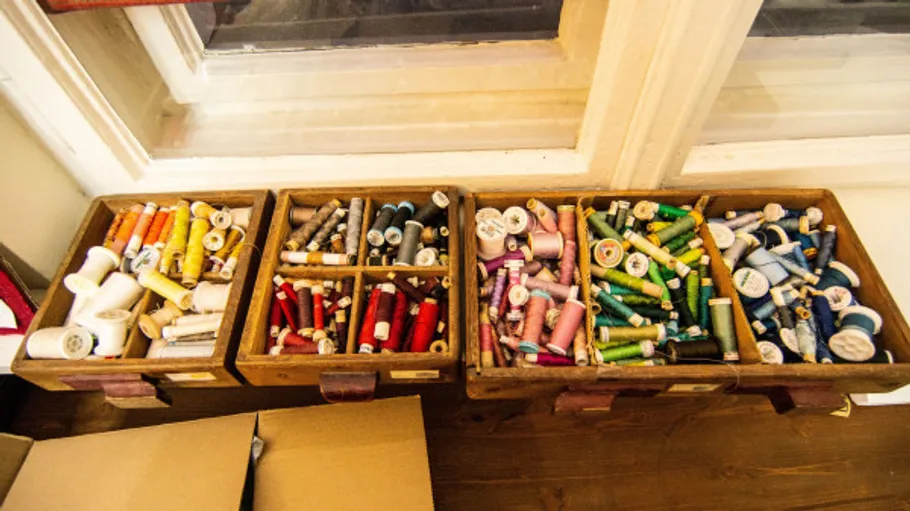 Wooden boxes with colorful sewing threads inside.