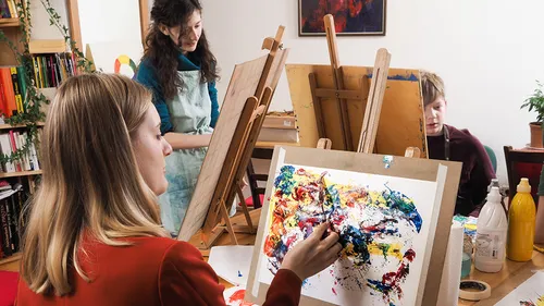 People painting in a classroom setting.