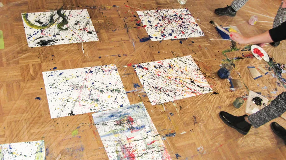 Gemälde mit Spritzern auf Atelierboden.