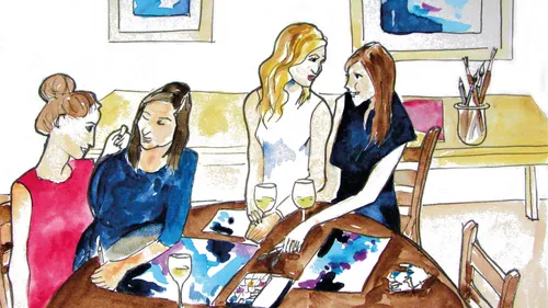 Four women around table painting and chatting.