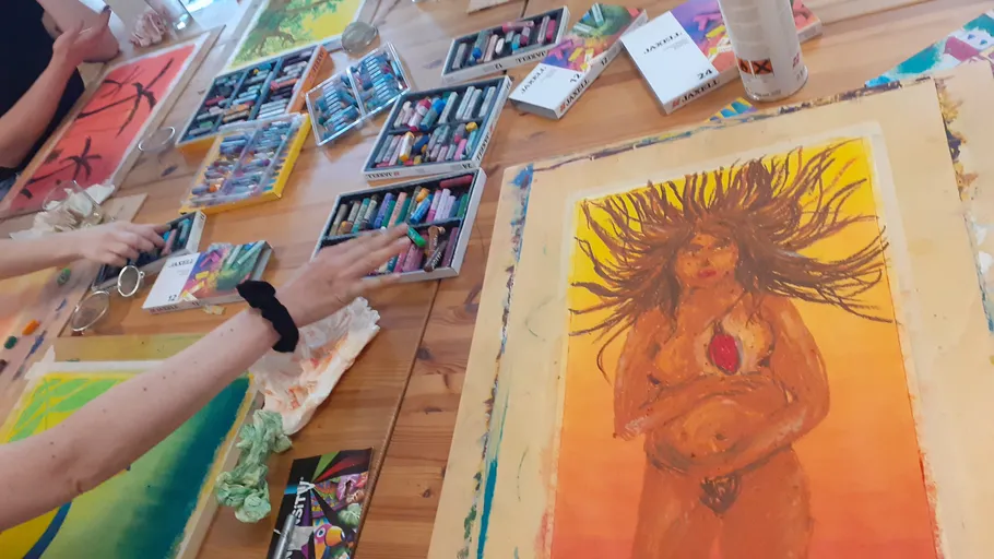 Hände zeichnen mit Pastellfarben auf Papier.