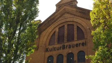 Brick building with 'KulturBrauerei' and trees.