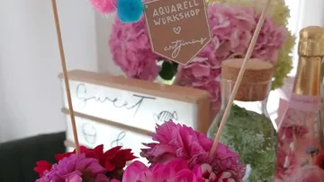 Flowers and sign with workshop text, decorative setting.