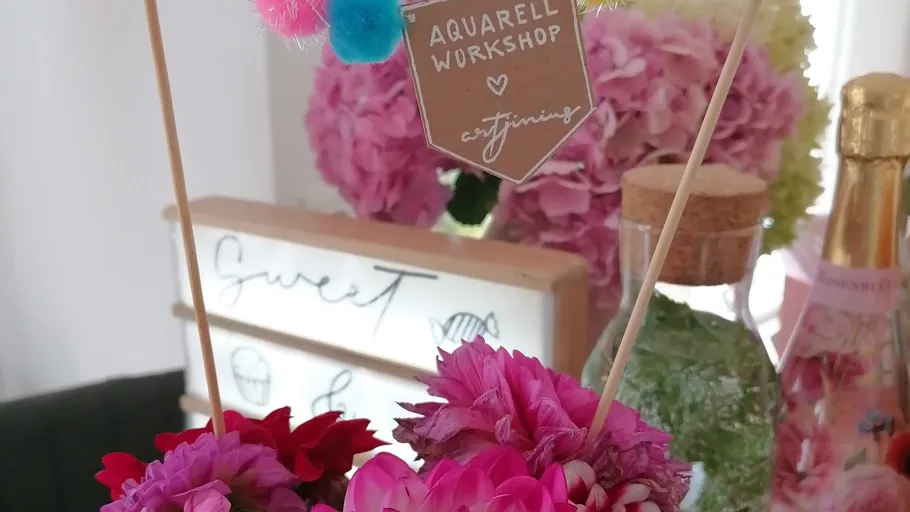 Blumen und Schild mit Workshop-Text, dekoratives Setting.