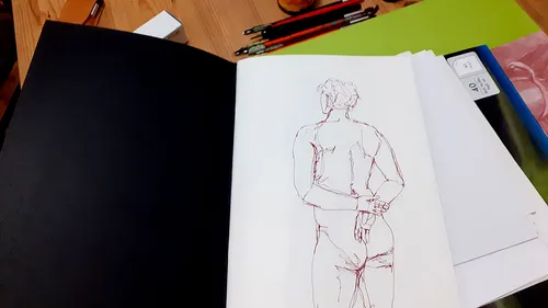 Skizzenbuch geöffnet mit einer Figurzeichnung innen.