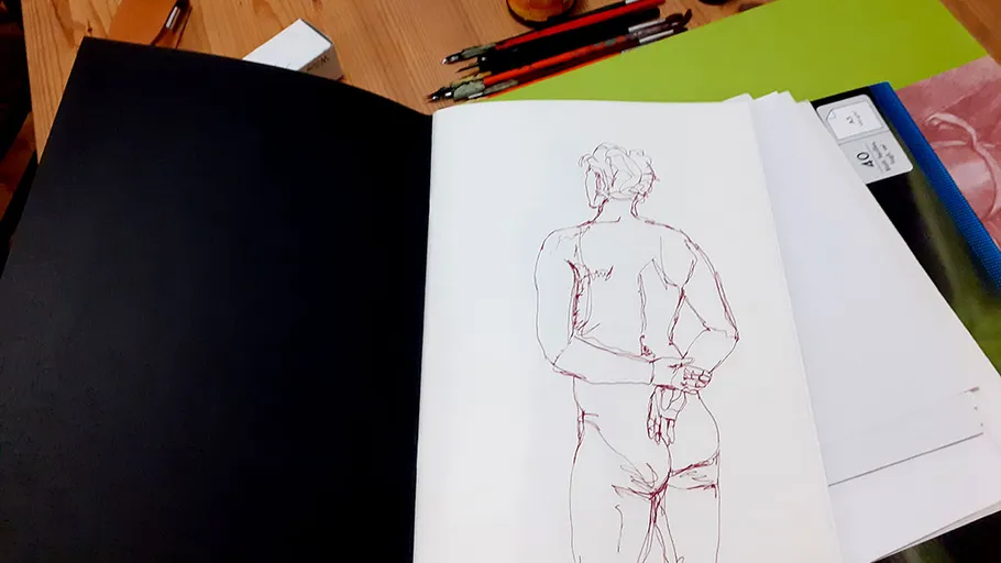 Skizzenbuch geöffnet mit einer Figurzeichnung innen.