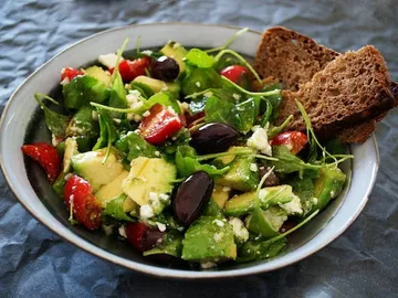 Schüssel mit frischem Salat, Gemüse und Brot.