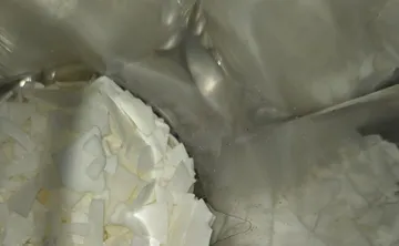 White flakes in a reflective metal container.