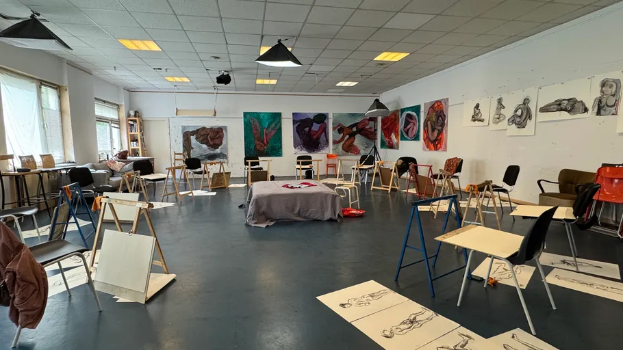 Art studio with chairs and artwork on walls.