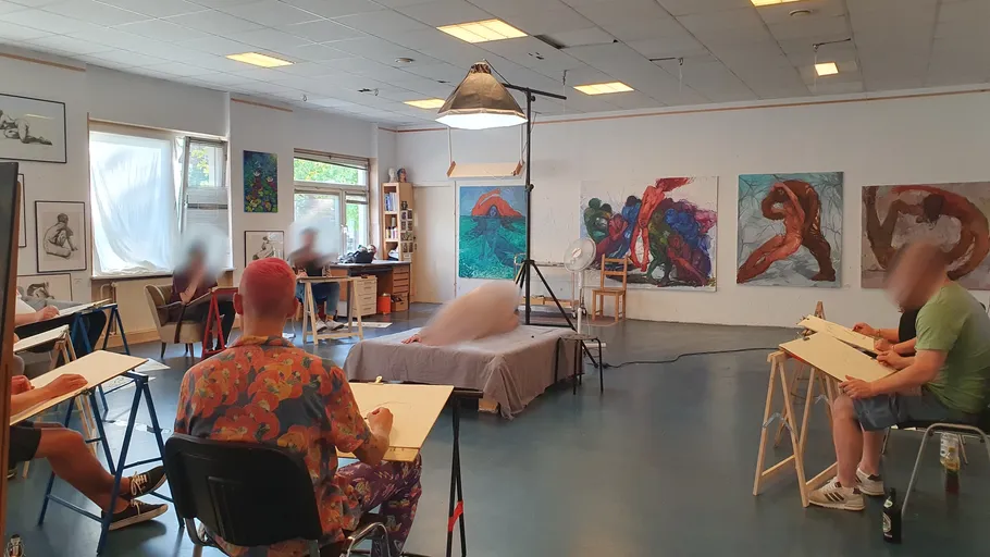 Menschen skizzieren ein Modell in einem Atelier.