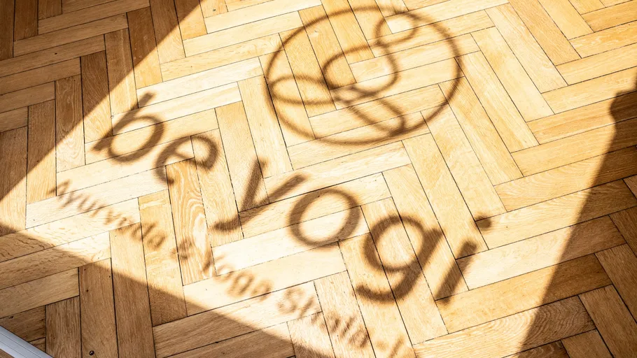 Schatten des Yogastudio-Logos auf Holzboden.