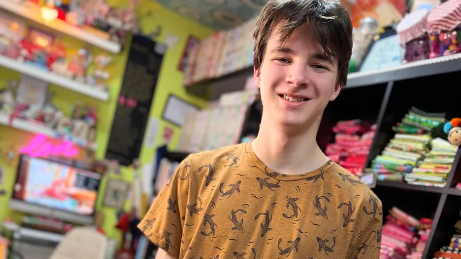 Smiling person in a colorful fabric store.