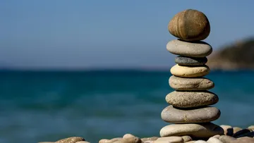 Stacked stones on a beach with ocean view.