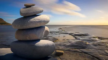 Stacked stones on seaside rocky surface.
