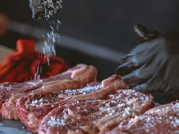 Meat is sprinkled with salt to season it.