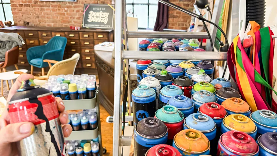 Spray cans on shelf in art studio.