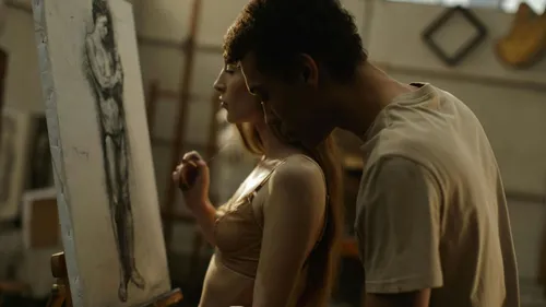 Two people observe a drawing in studio.