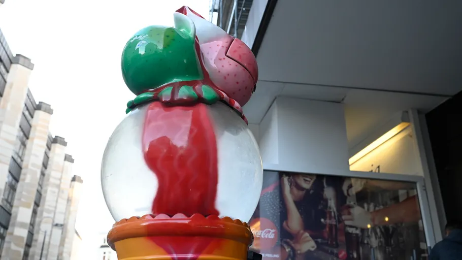 Colorful ice cream sculpture outside urban building.