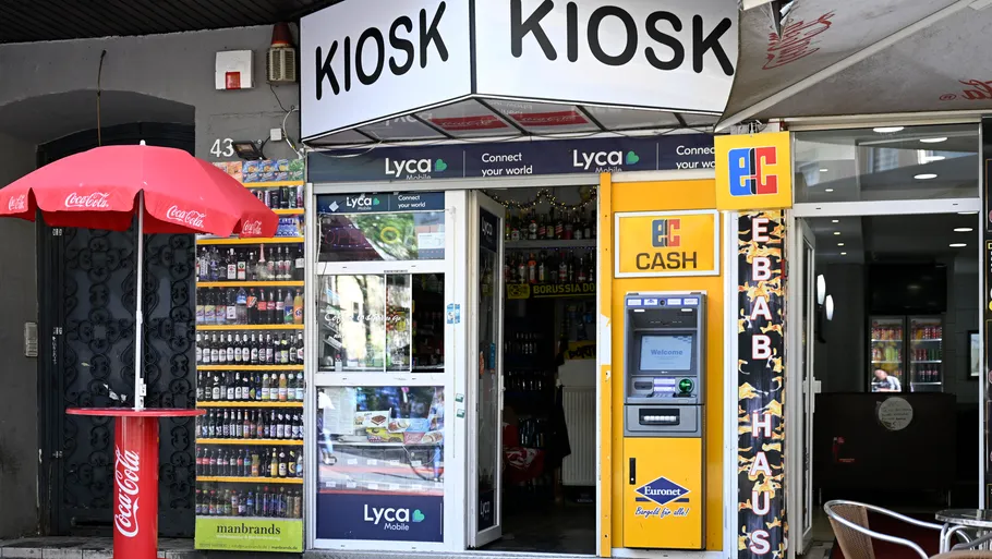 Kiosk entrance with drinks and ATM outside.