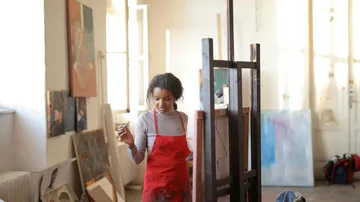 Artist painting in a bright art studio.