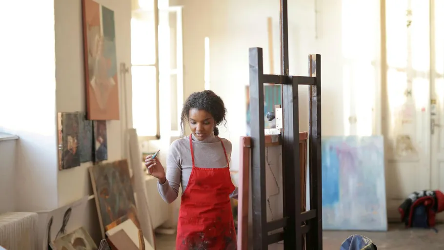 Artist painting in a bright art studio.