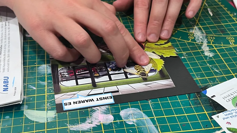 Hands assembling collage on cutting mat.