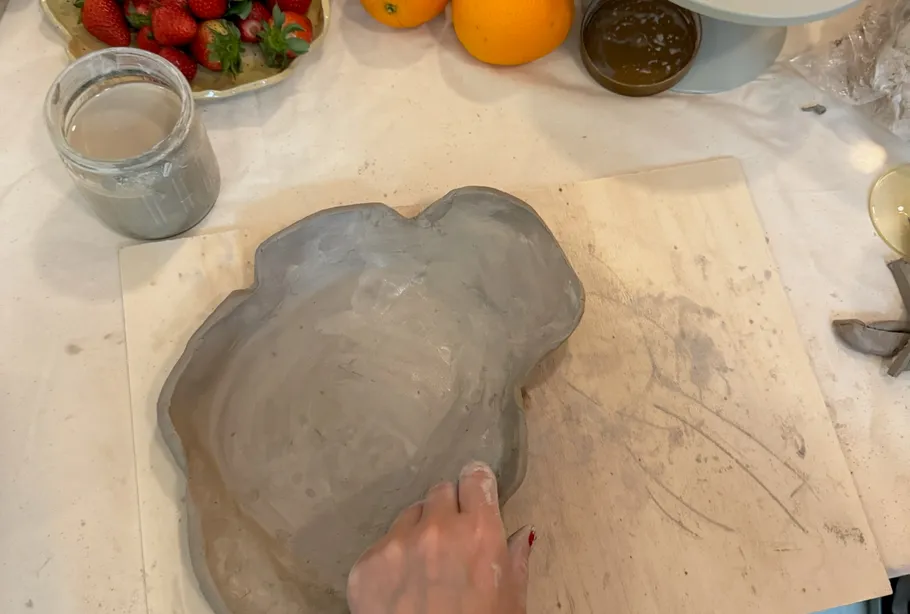 Person formt Tonschale auf Tisch.