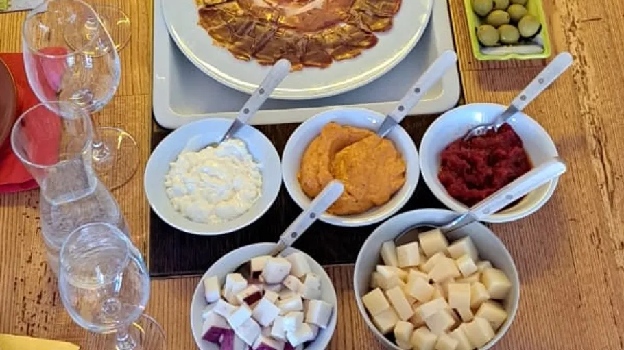 Käse und Aufstriche mit Messern auf einem Tisch.