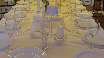 Elegant table setup with white plates, wine glasses.
