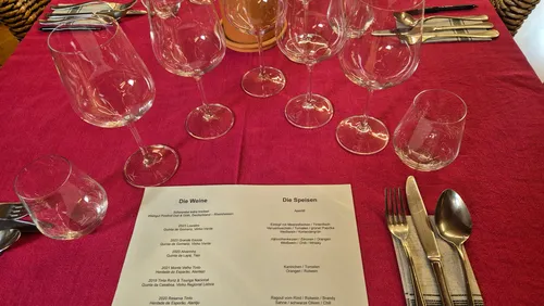 Table setting with glasses, utensils, menu.