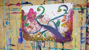 Abstraktes Blumenbild auf bunter Wand.