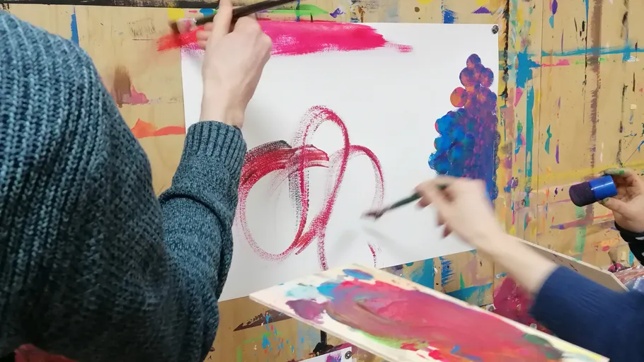 Hände malen abstrakte Kunst auf Papier.