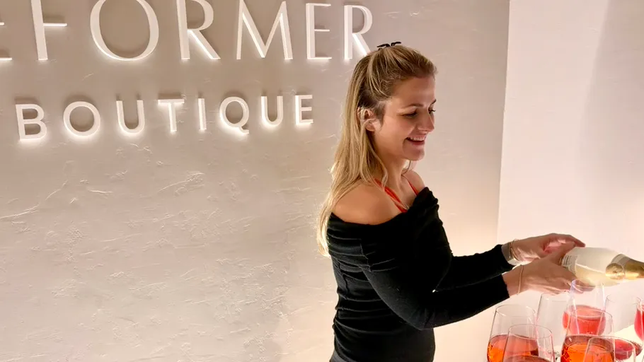 Frau schenkt Getränke in stilvoller Boutique ein.