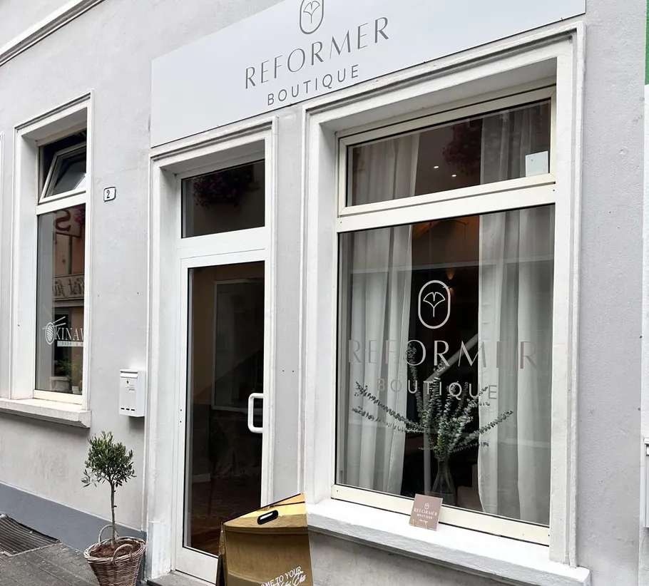 Ladenfront mit Boutiqueschild und Schaufensterdeko.