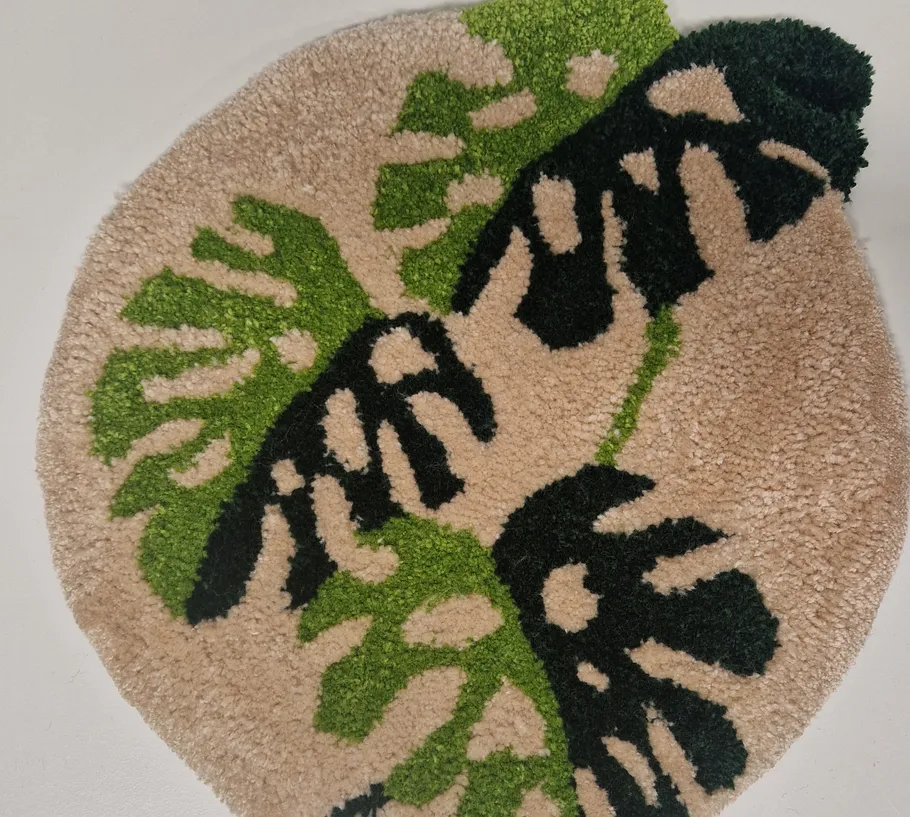 Round rug with green leaf design.