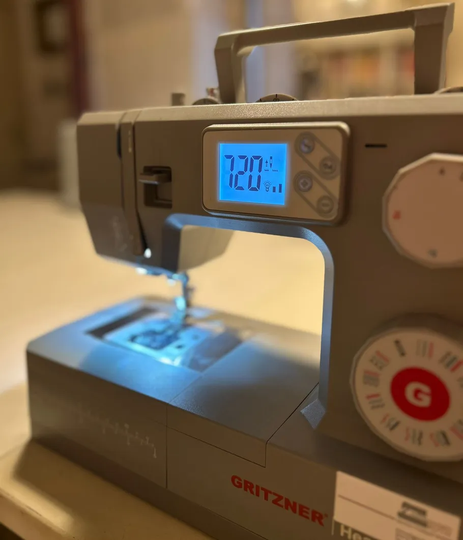 Sewing machine with illuminated digital screen.