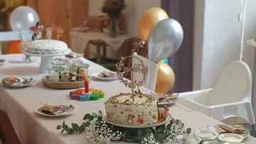 Decorated cake on table with balloons.