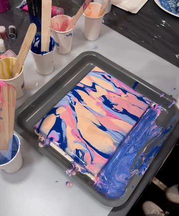Canvas with abstract paint in a tray.