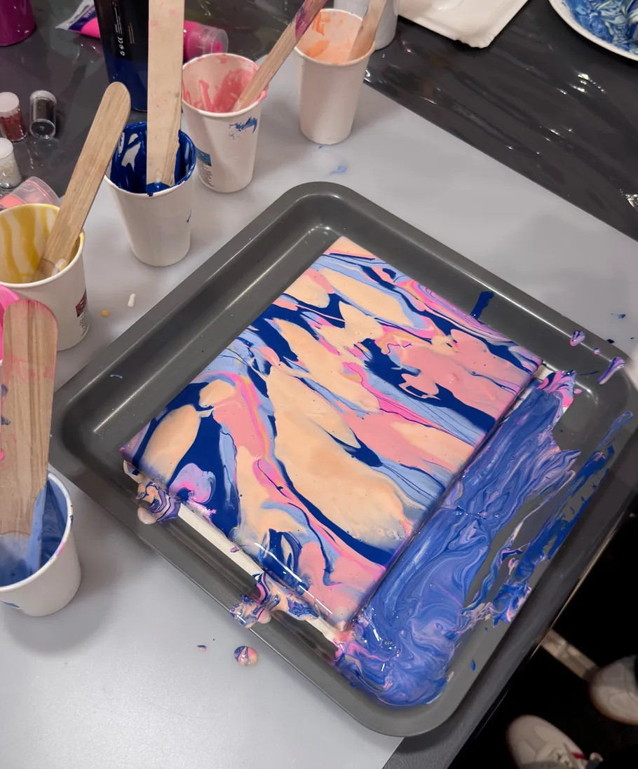 Canvas with abstract paint in a tray.