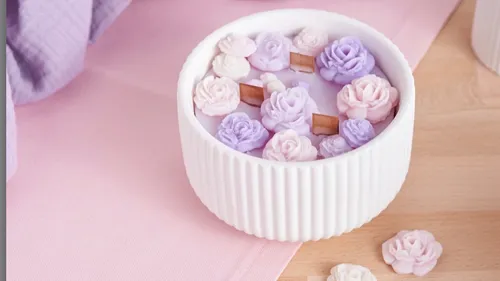 White candle with purple flower decorations.
