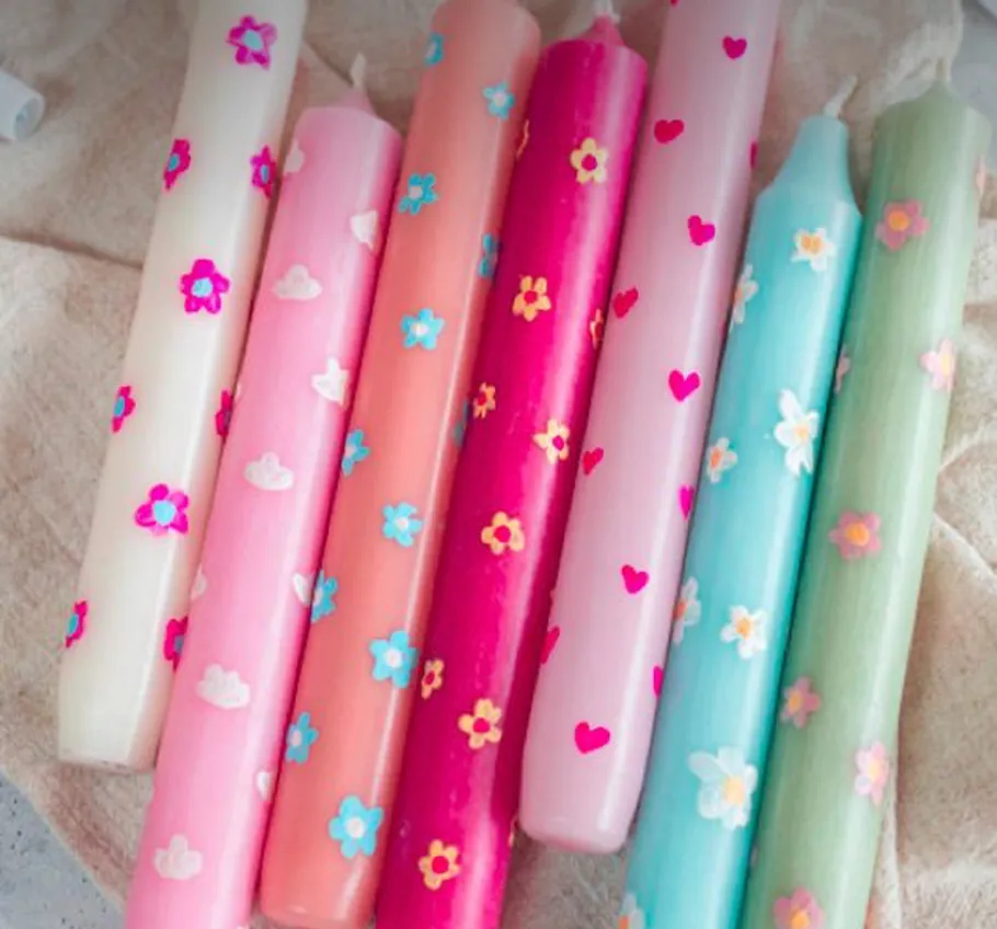 Colorful patterned candles on a cloth.