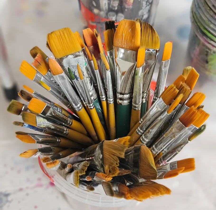 Malpinsel stehen in einem klaren Behälter.