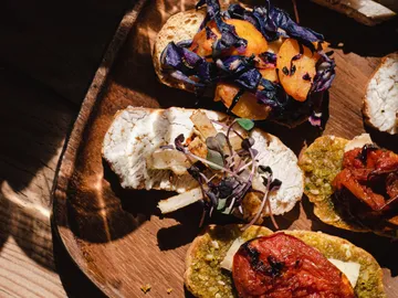 Pieces of bread with colorful toppings on a wooden board.