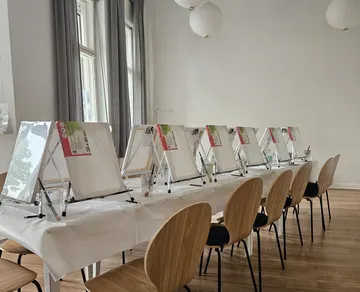 Art workshop setup with easels and chairs.