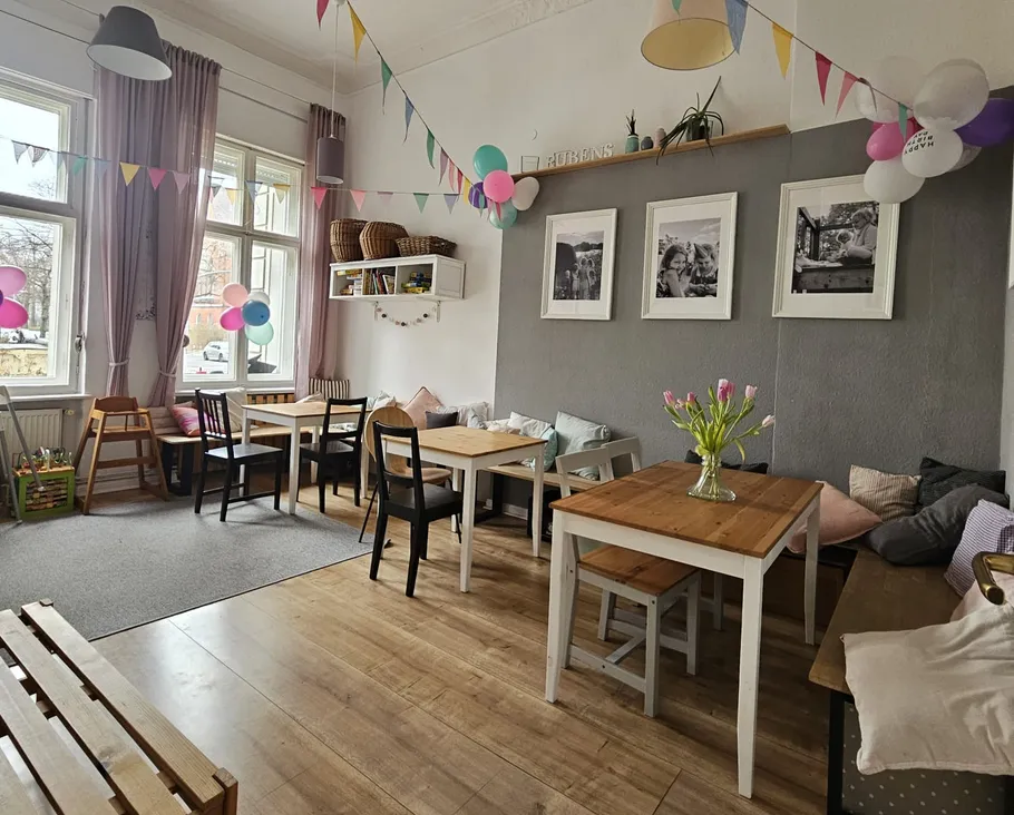 Gemütliches Café mit Holztischen und Dekorationen.